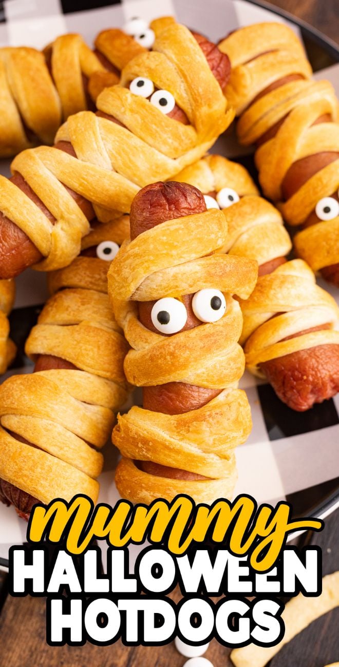 These mummy Halloween hot dogs are hot dogs wrapped in crescent roll dough to look like mummies with candy eyes, served on a plate—a spooky and fun Halloween party recipe!.