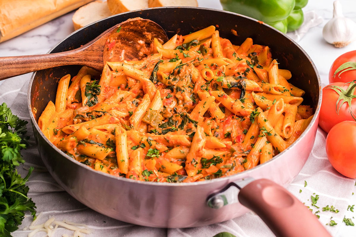 Overhead view of penne pasta with a rosa sauce in a pan.
