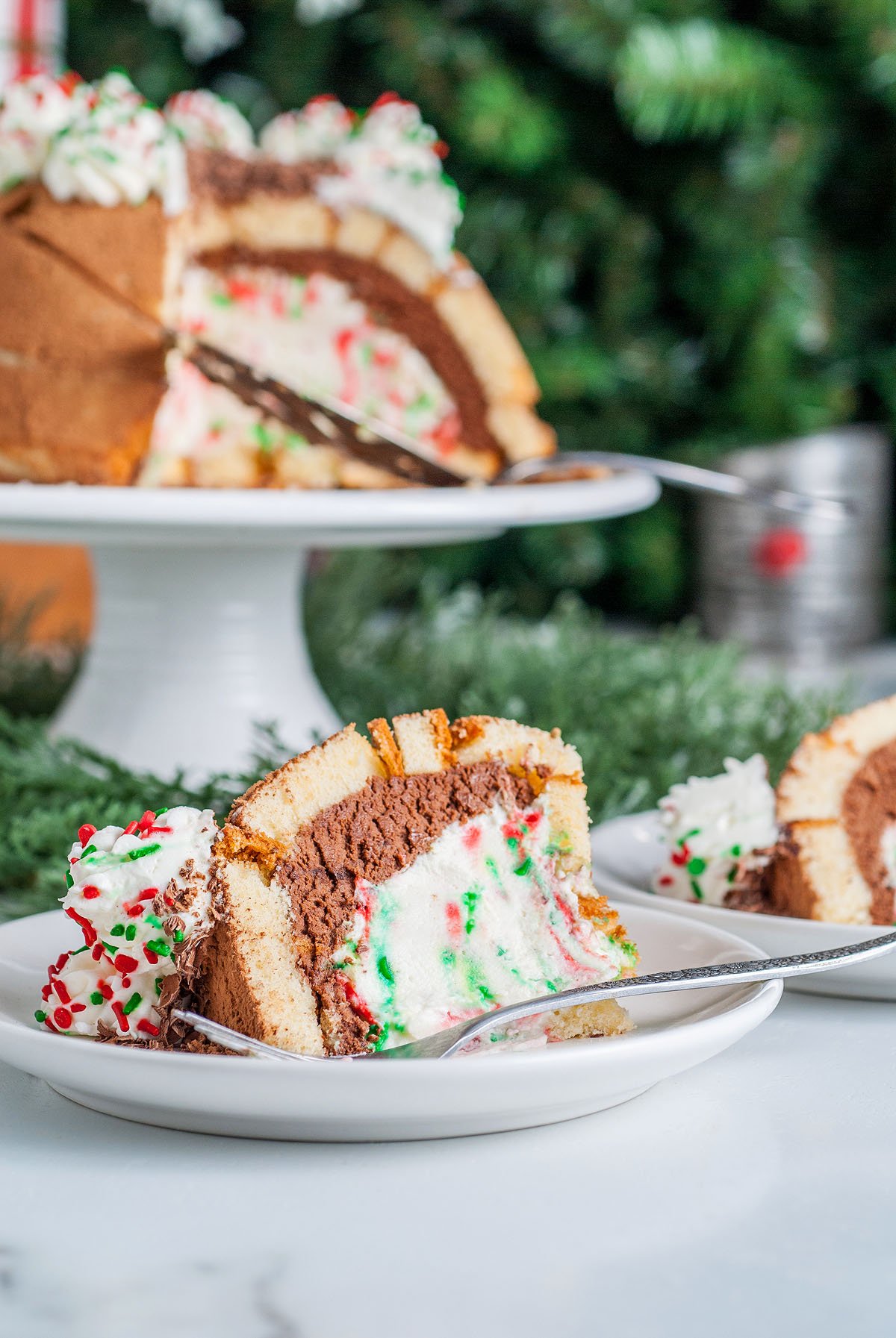 A festive slice of Italian Christmas Zuccotto Cake with sprinkles, served on a plate with a fork, captures the spirit of traditional Italian Christmas desserts.