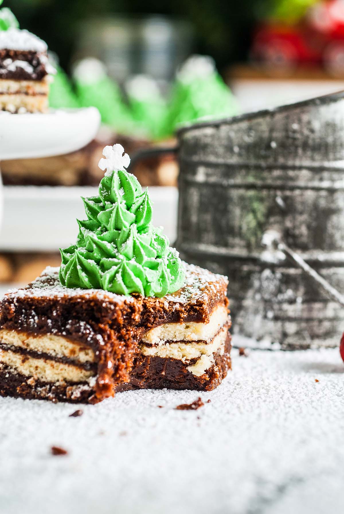A Mint Milano Christmas Brownie square, decorated with a green frosting Christmas tree and dusted with powdered sugar, makes a festive holiday treat.