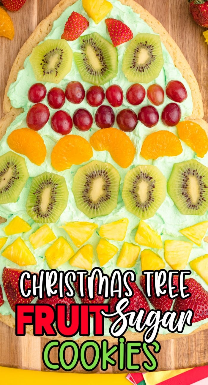 A Christmas Tree Fruit Sugar Cookie, this festive tree-shaped treat features green frosting and assorted fruit slices, making it a delightful Christmas dessert.