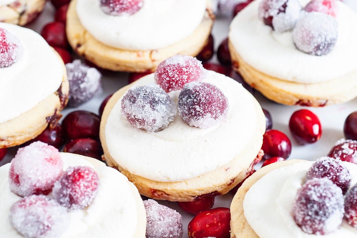 Sparkling Frosted Cranberry Cookies topped with sugared cranberries, surrounded by fresh and sparkling cranberries.