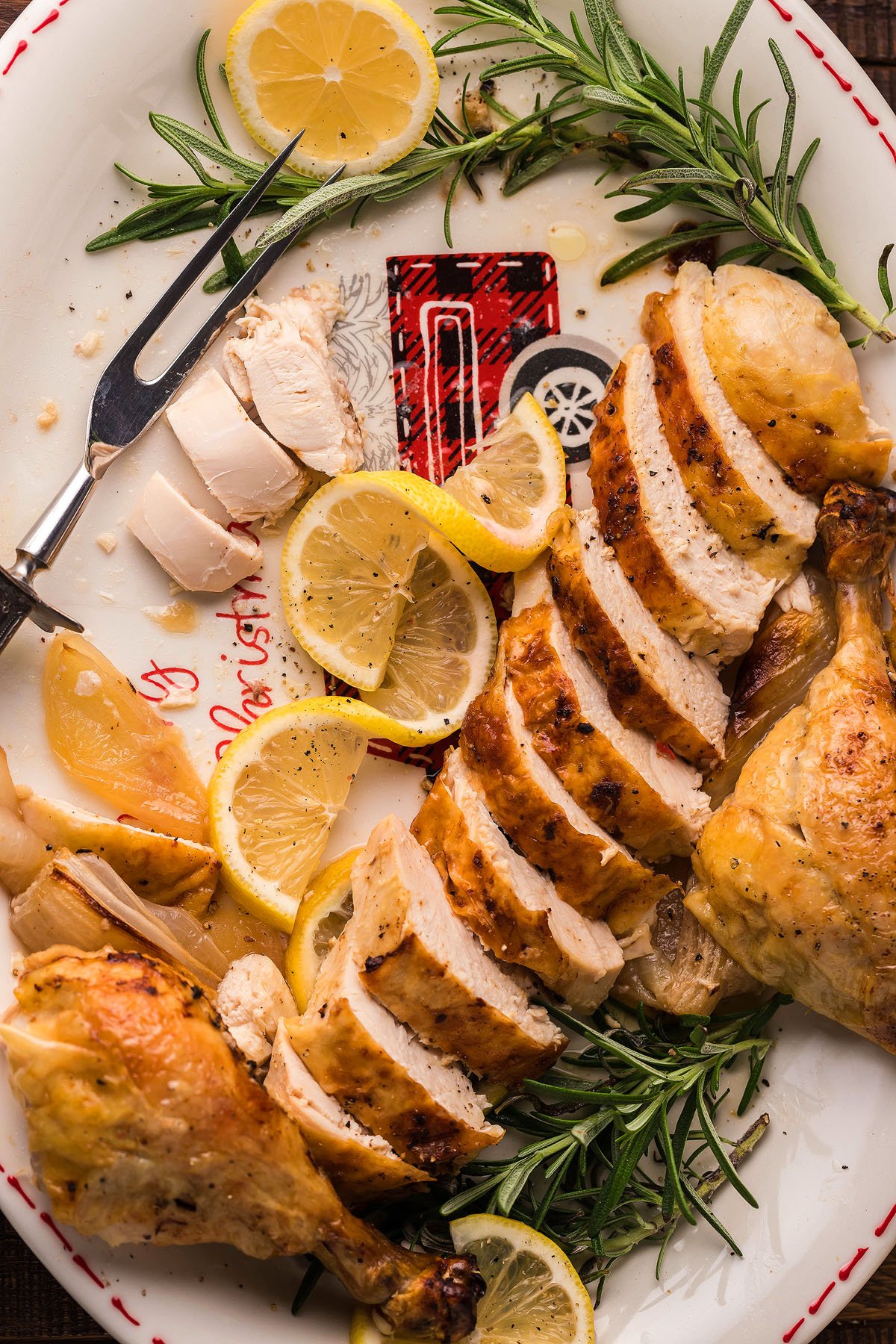 roasted whole chicken sliced on a plate with lemon