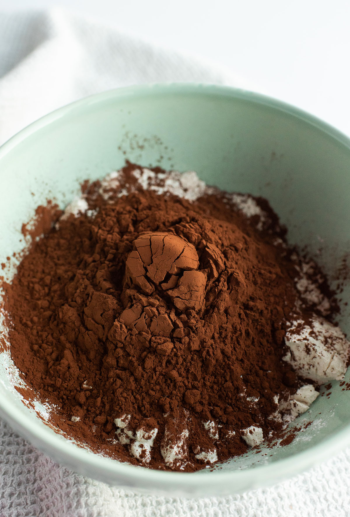 A bowl with cocoa powder and flour, ready to be mixed for baking delicious Caramel Stuffed Chocolate Cookies.