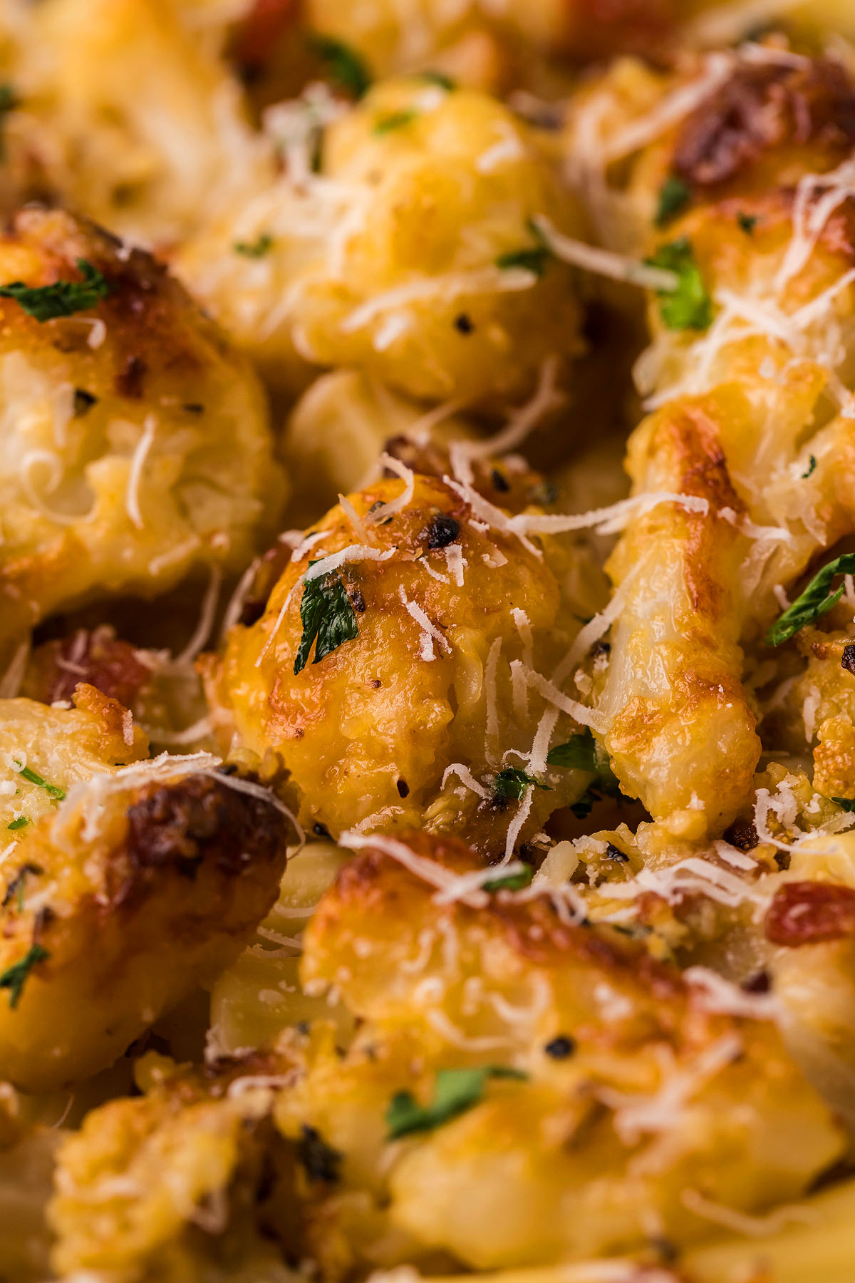 Close-up of Roasted Cauliflower Carbonara, featuring roasted florets topped with grated cheese and chopped herbs—an easy weeknight dinner with a creamy cauliflower sauce twist.