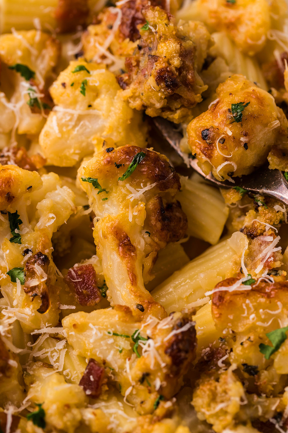 Close-up of Roasted Cauliflower Carbonara with grated cheese, herbs, and browned bits of bacon or sausage—a comforting, easy weeknight dinner with a creamy cauliflower sauce.