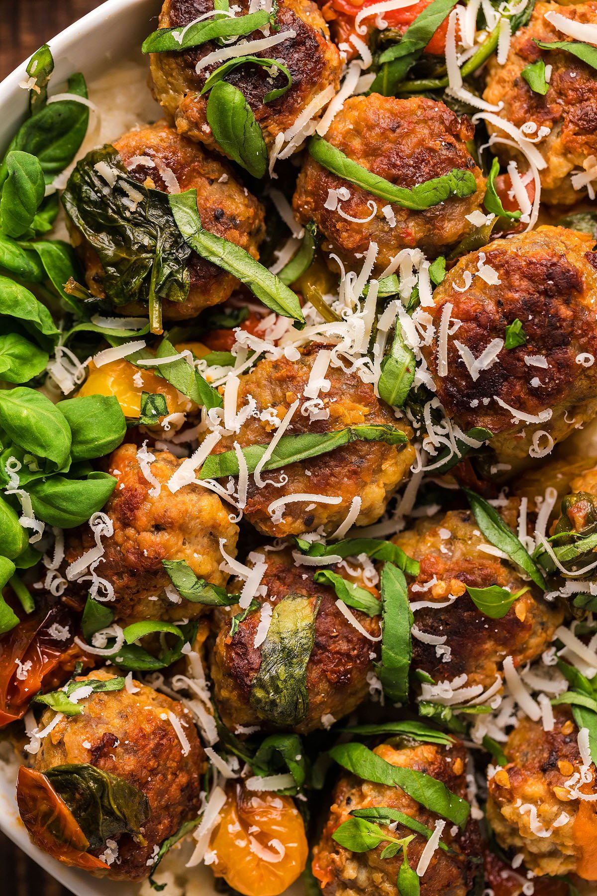 Meatballs with fresh basil, grated cheese, and roasted tomatoes on a bed of rice—perfect for gluten free meatball recipe seekers and those looking for classic Italian meatball dinner ideas.