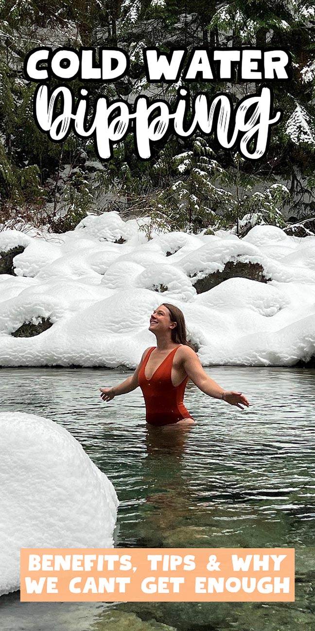 A woman in a red swimsuit stands in a snowy river, arms outstretched, surrounded by snow-covered trees.
