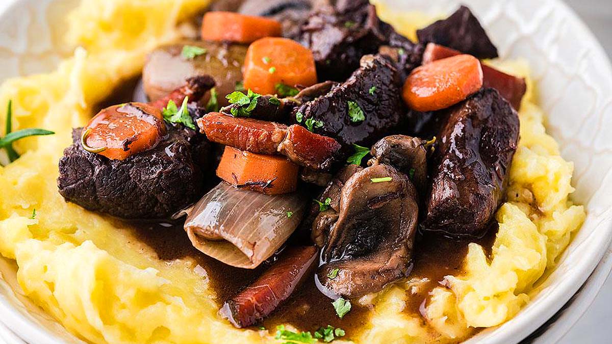 Boeuf bourguignon in a bowl with mash potatoes.