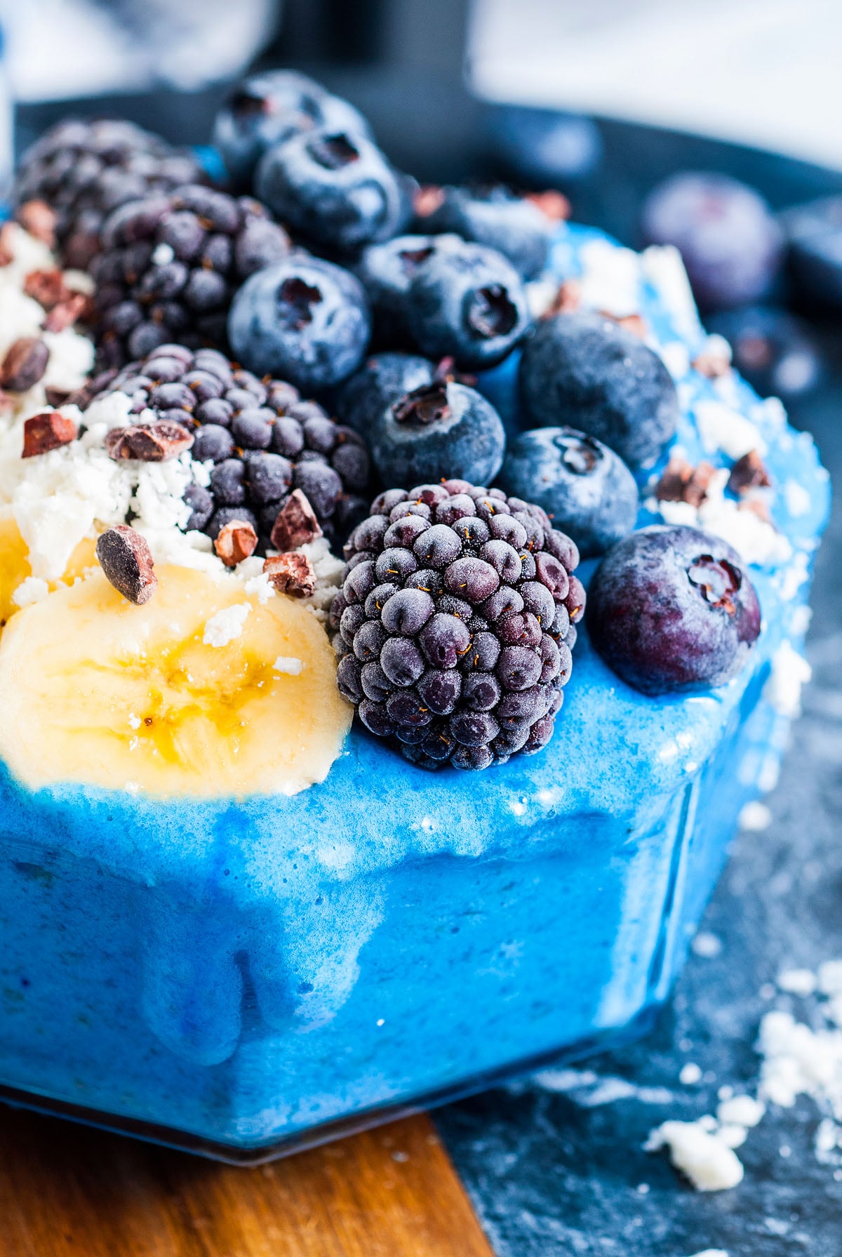 Blue Smoothie Bowl with Spirulina, topped with blackberries, blueberries, banana slices, and cacao nibs.