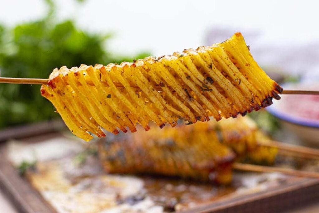 A skewer with an accordian cut potato.