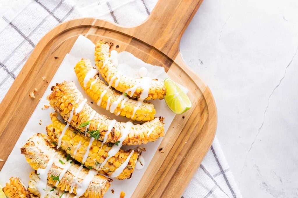 Corn ribs on a wooden platter with toppings