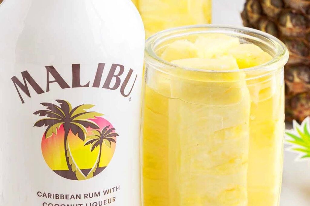 A mason jar with pineapple and rum.