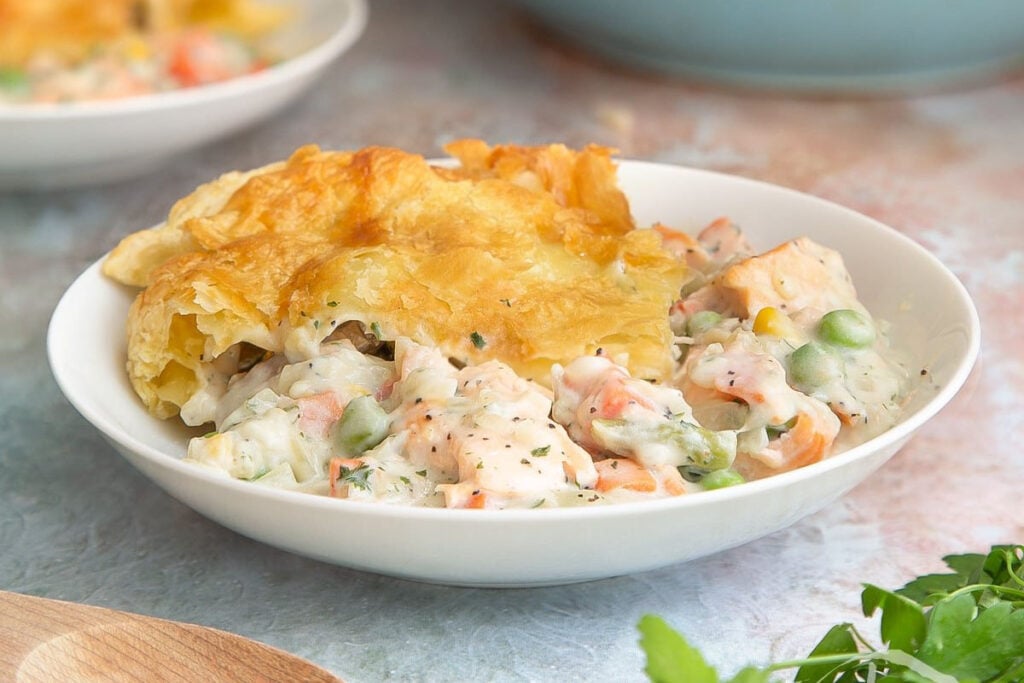 Flaky crust with creamy salmon and vegetable filling in a white bowl