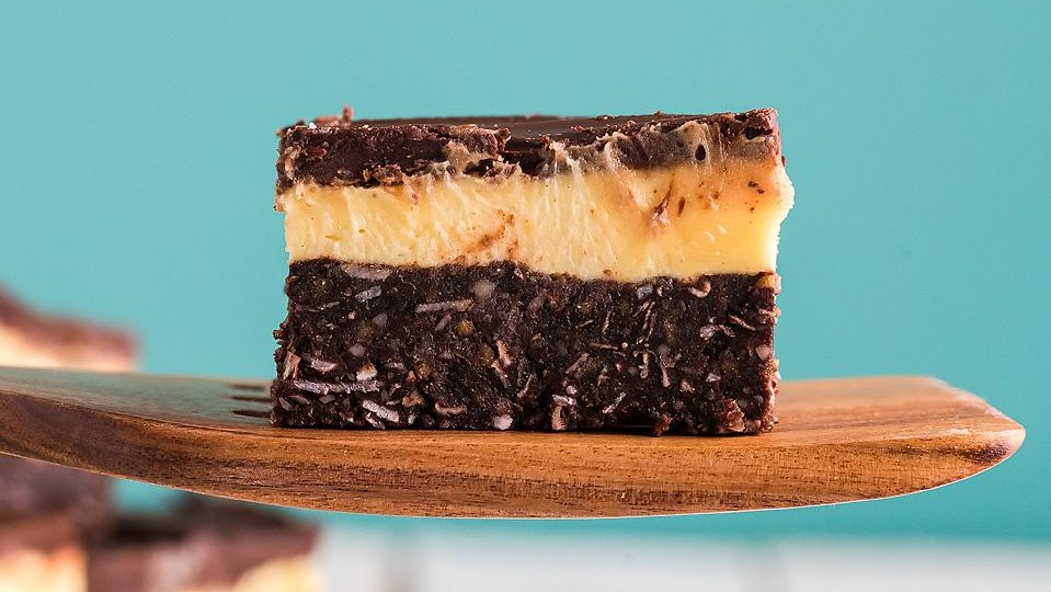 A nanaimo bar on a wooden spoon.