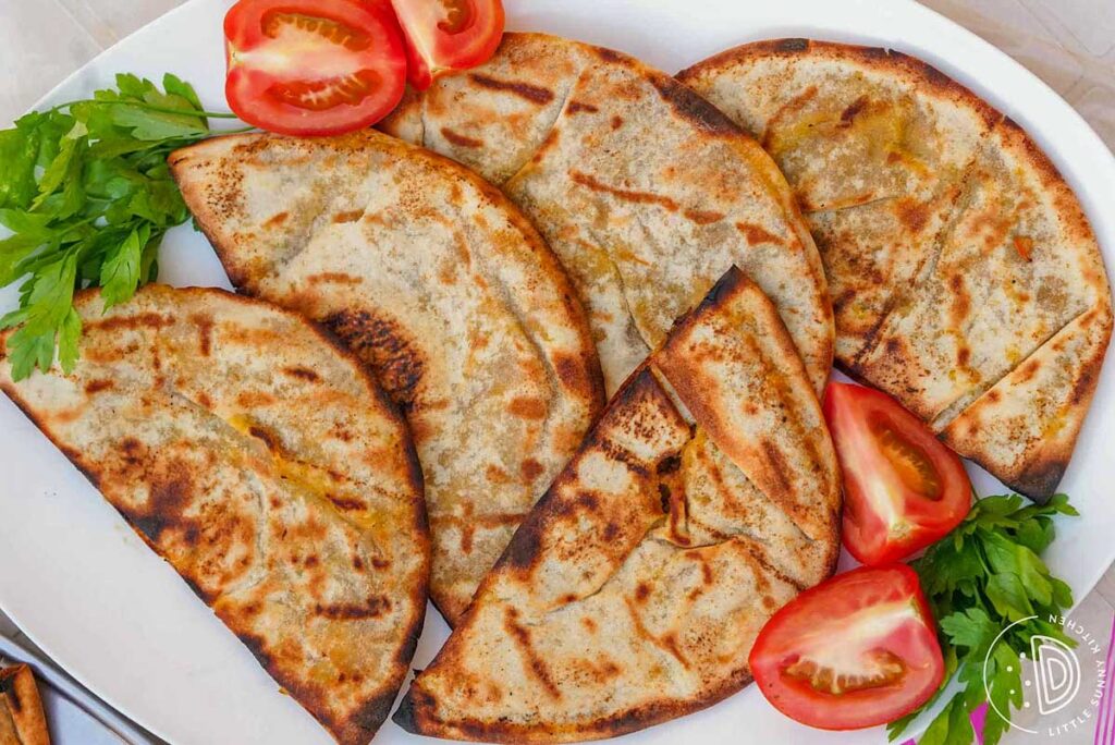 meat stuffed pita on a white plate