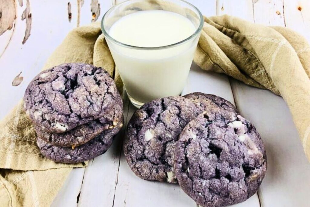 Blueberry white chocolate cookies with a glass of milk.