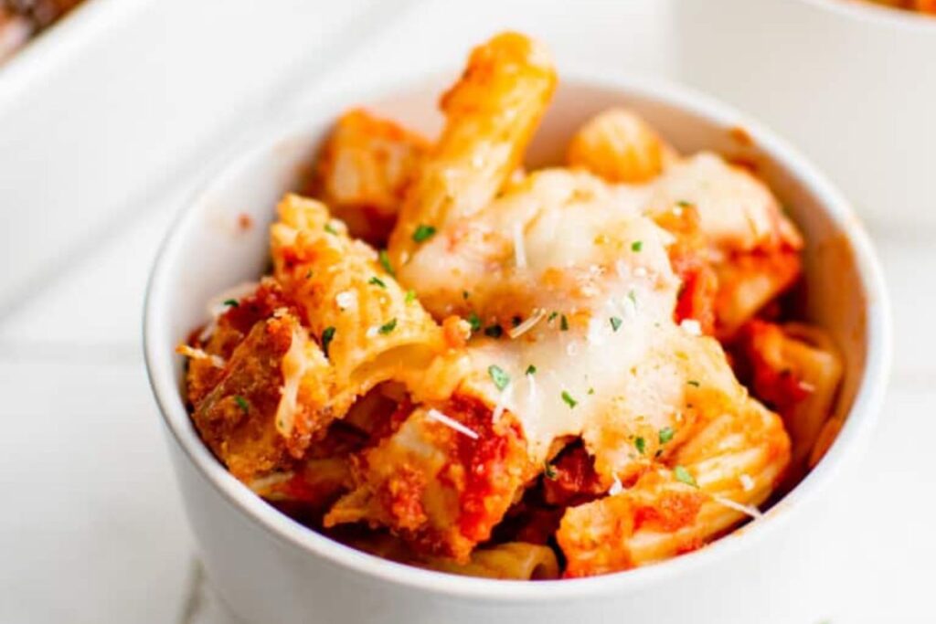 A bowl with chicken parm pasta casserole.