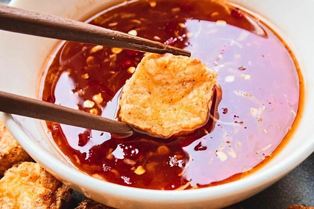 A plate of tofu with sweet chili sauce.