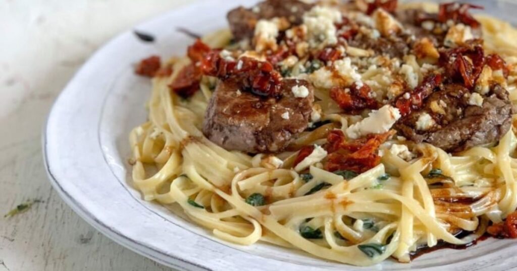 A plate of pasta with gorgonzola steak.