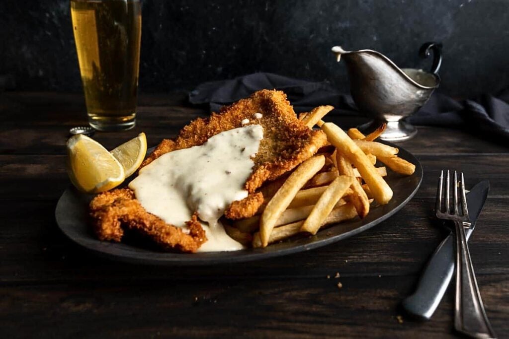 A schnitzel fried to perfection and topped with fondue sauce.