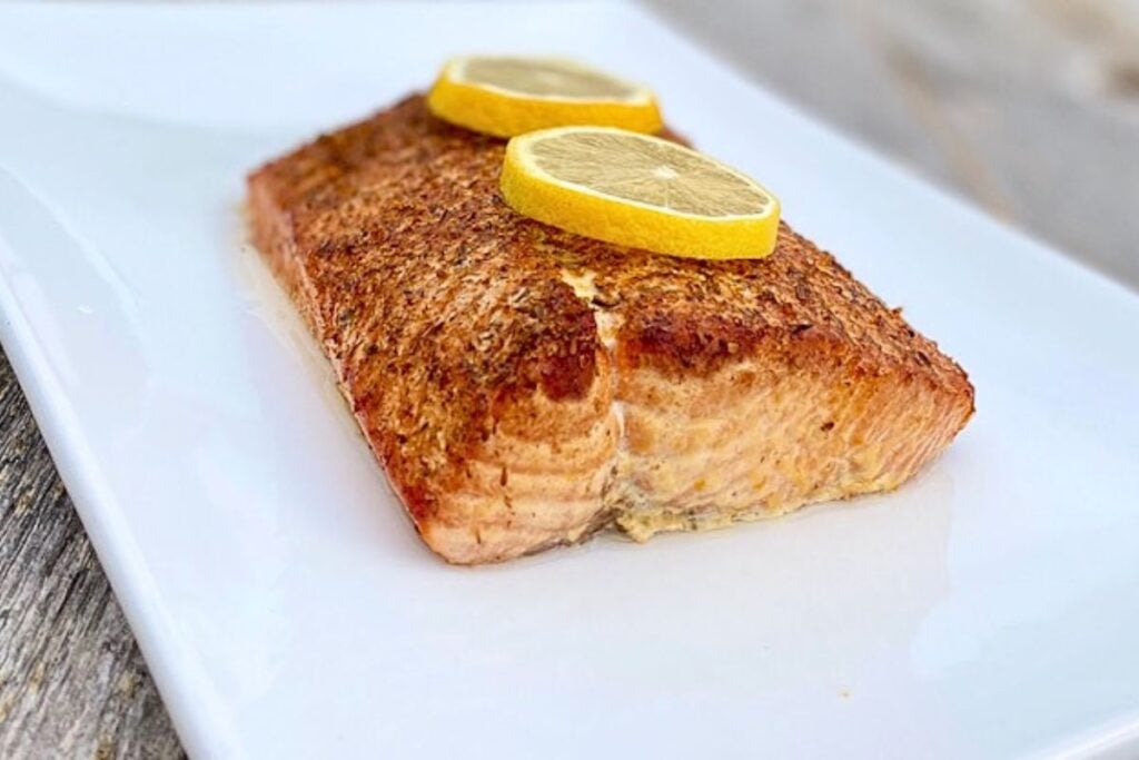 A salmon with lemon slices on top.
