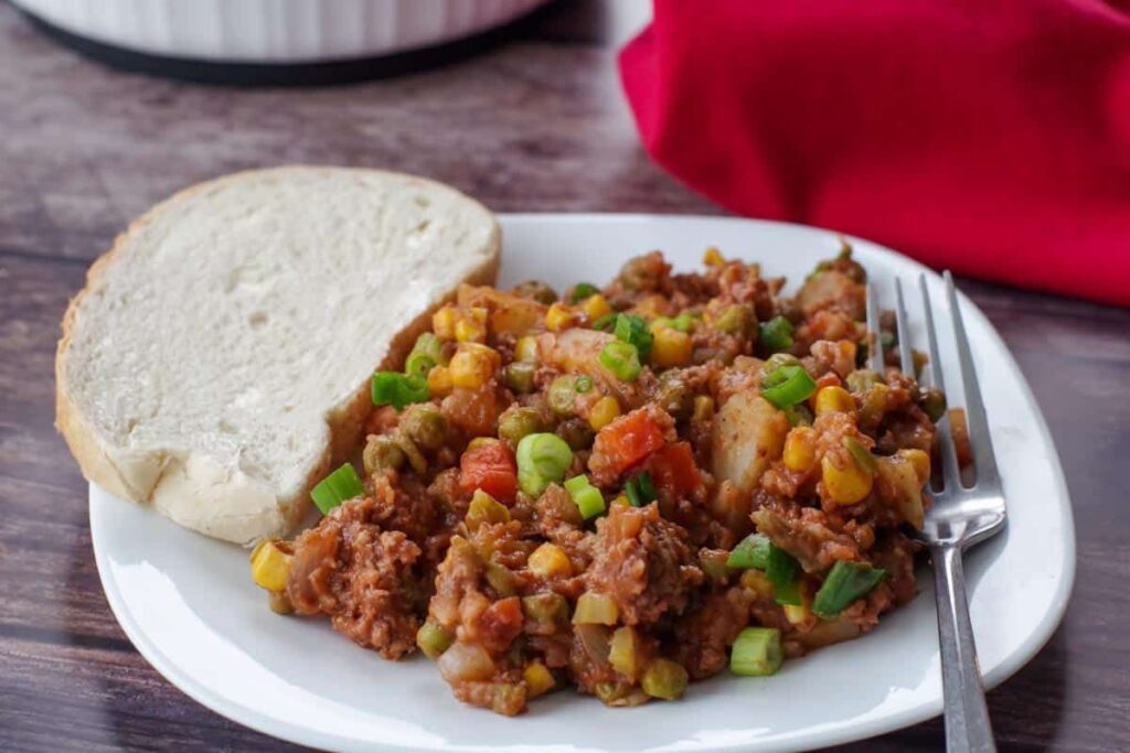 A helping of shipwreck casserole with mixed frozen veggies.