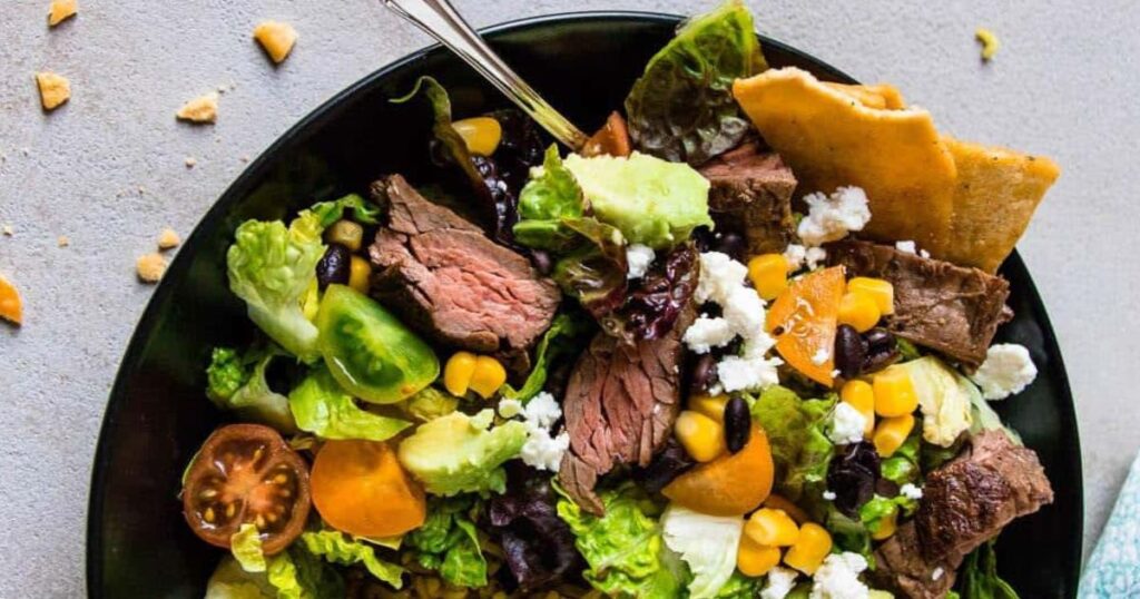 A bowl of carne asada steak and rice.