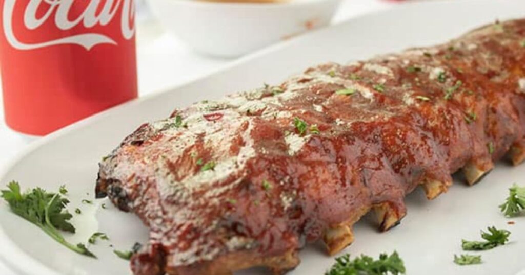 A rack of saucy ribs on a platter.
