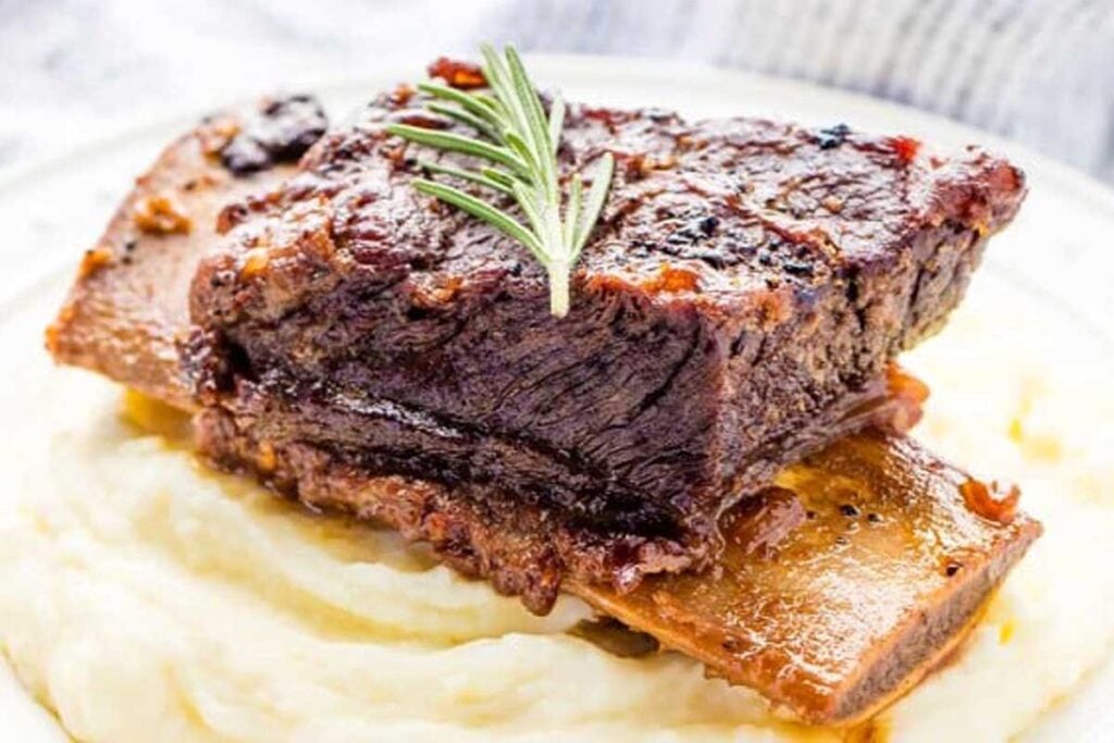 Slow cooker beef short rib on a bed mash potatoes.
