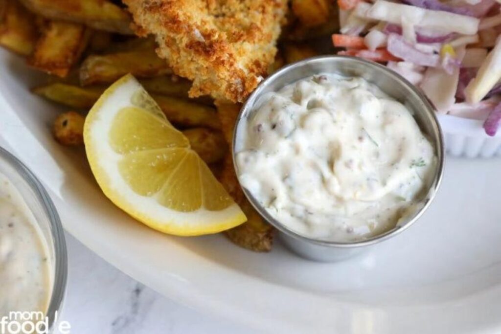 A small dish of tartar sauce with fish and slaw.