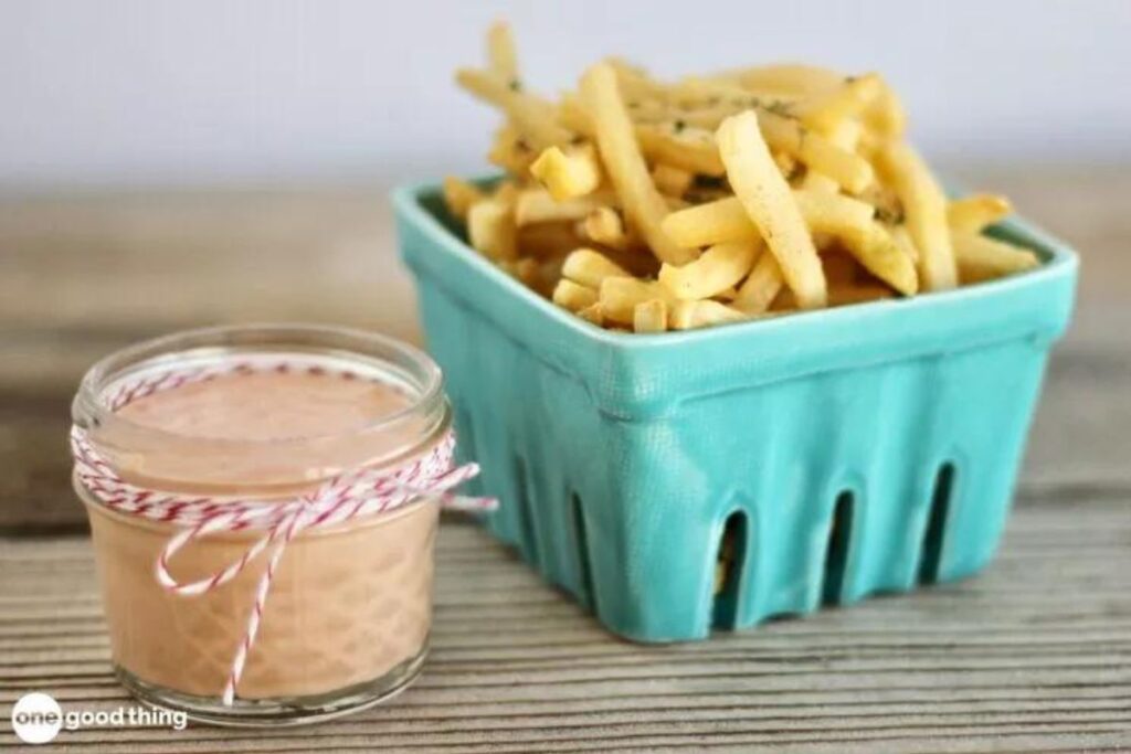 A small jar of fry sauce with fries.