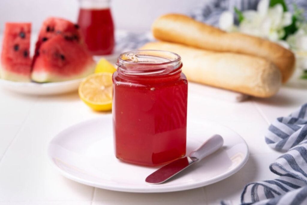 A jar of clear pink watermelon jam.
