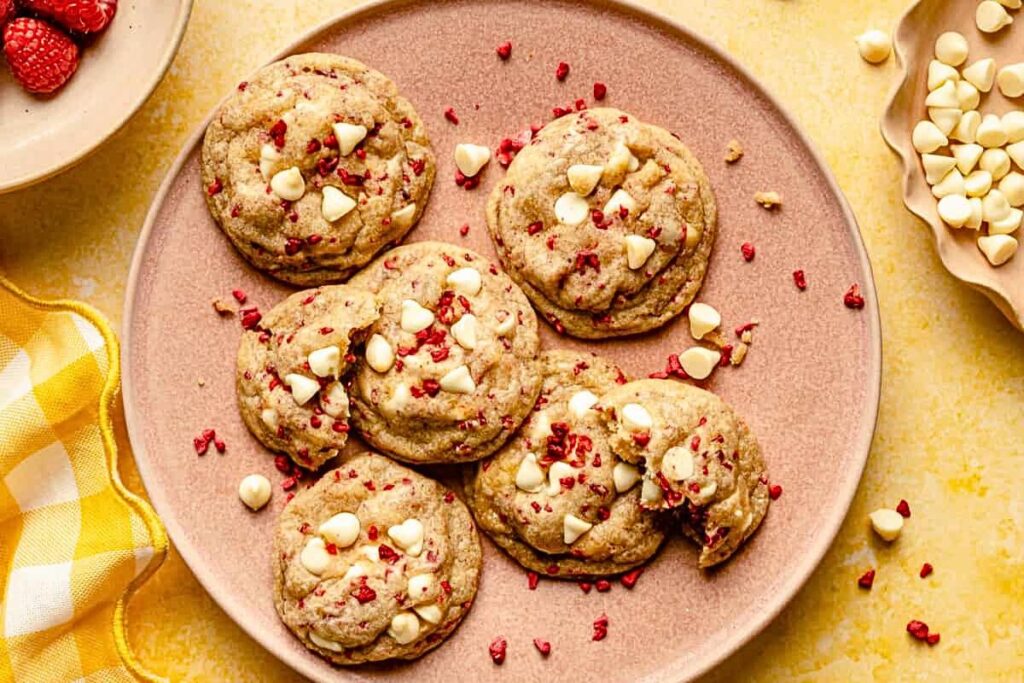 A plate of cookies with raspberry and white chocolate.