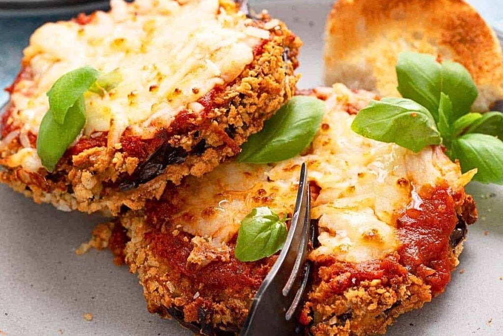 Crispy eggplant with cheese and sauce on a plate.