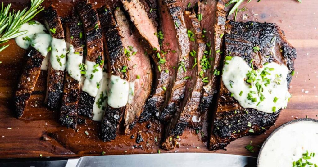 A sliced bavette steak with garlic butter sauce.