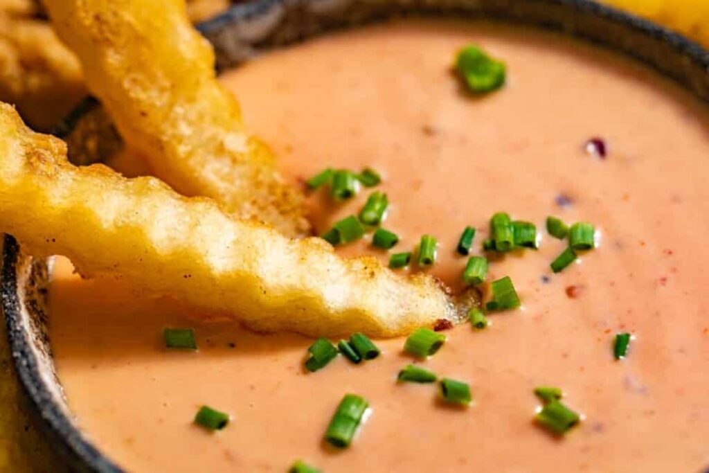 A bowl of boom boom sauce with fries.
