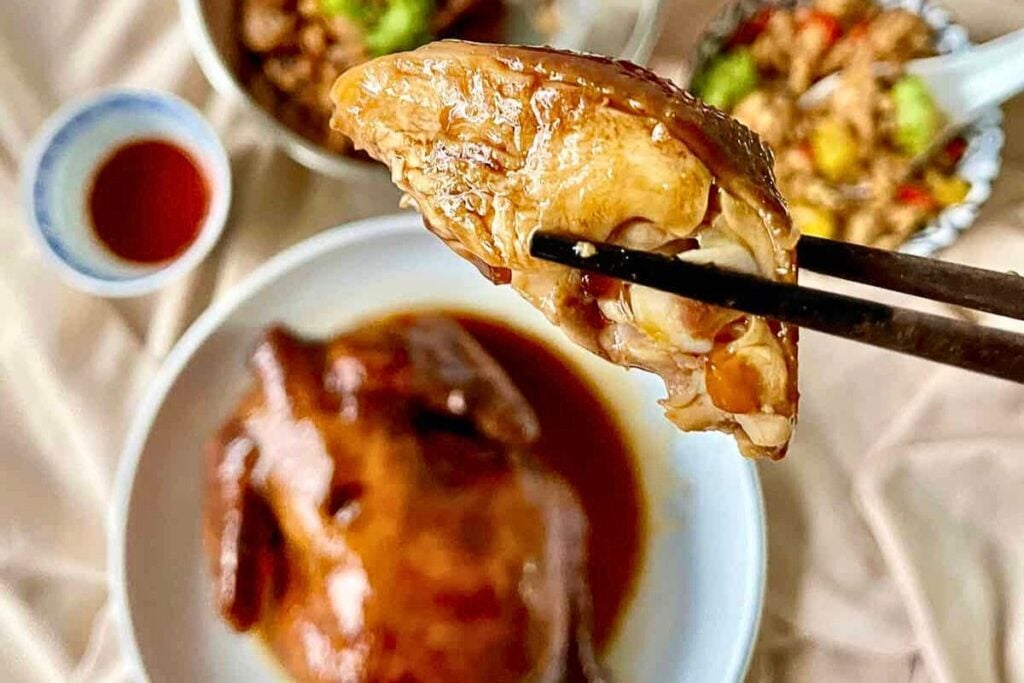 Chopsticks holding chicken.