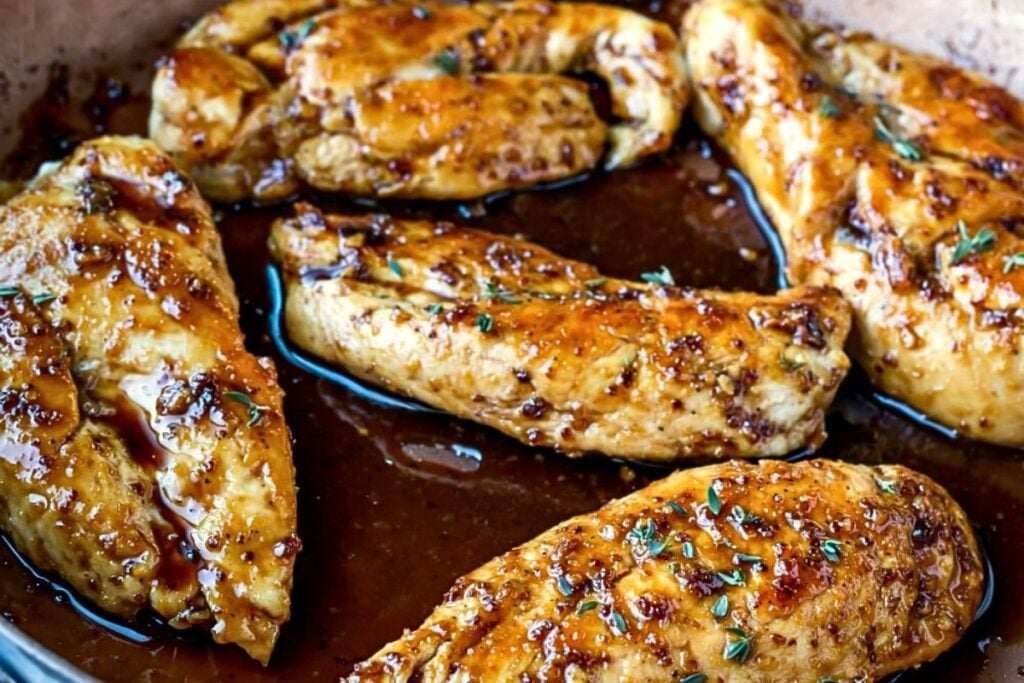 A skillet of chicken breasts with maple mustard glaze.