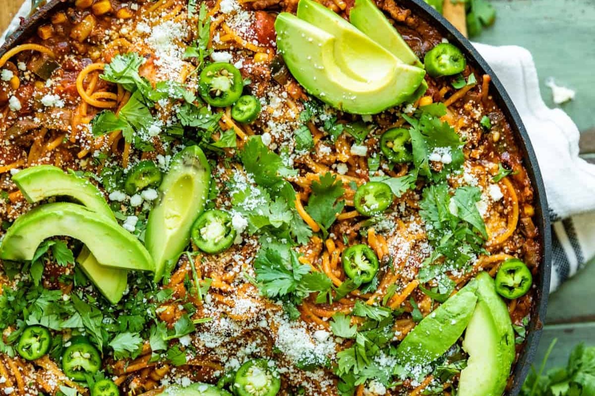 A skillet with spicy Mexican spaghetti topped with jalapenos.