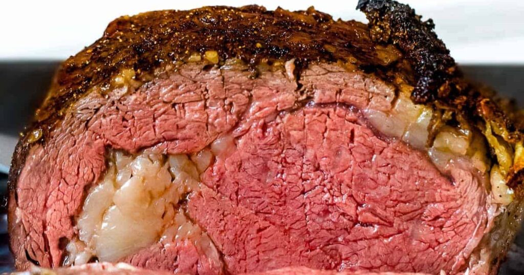 A prime rib roast being sliced.