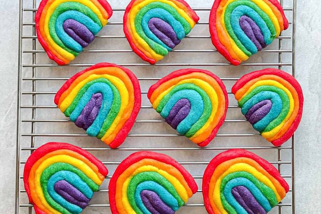 Sugar cookies shaped like colorful rainbows.