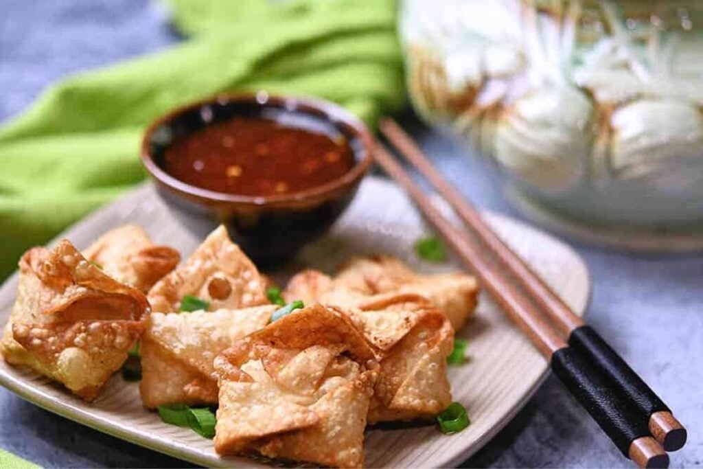 A plate of shrimp rangoon with chili dipping sauce.