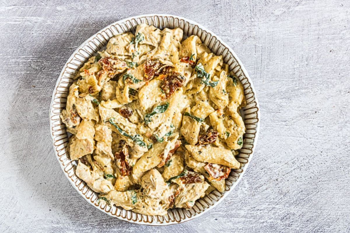 A bowl of creamy Tuscan chicken pasta.