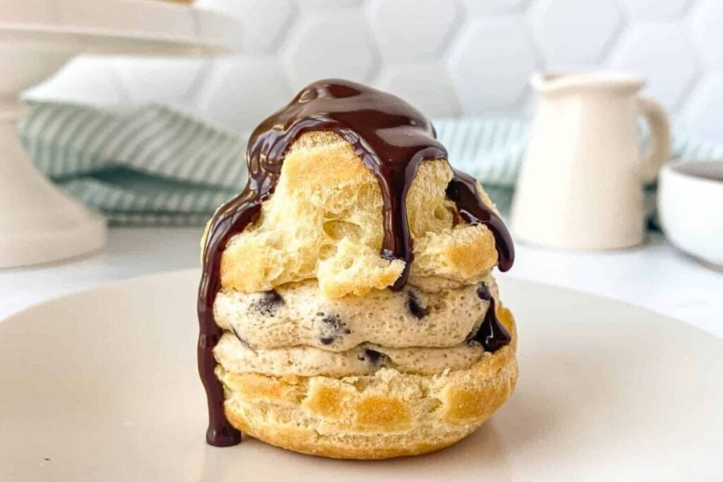 Cream puff filled with cookie dough and ganache poured over top.