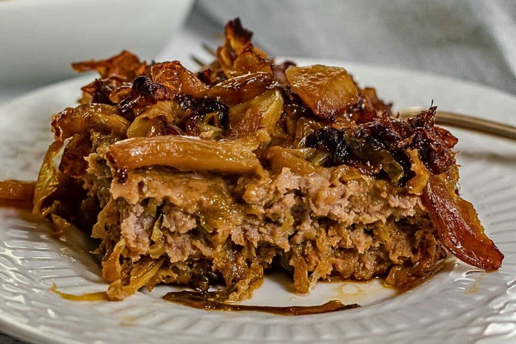 Caramelized cabbage and ground beef meatloaf on a plate.