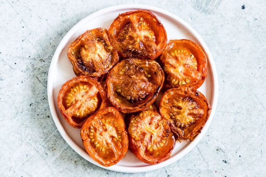 A plate of baked tomato slices with cinnamon.