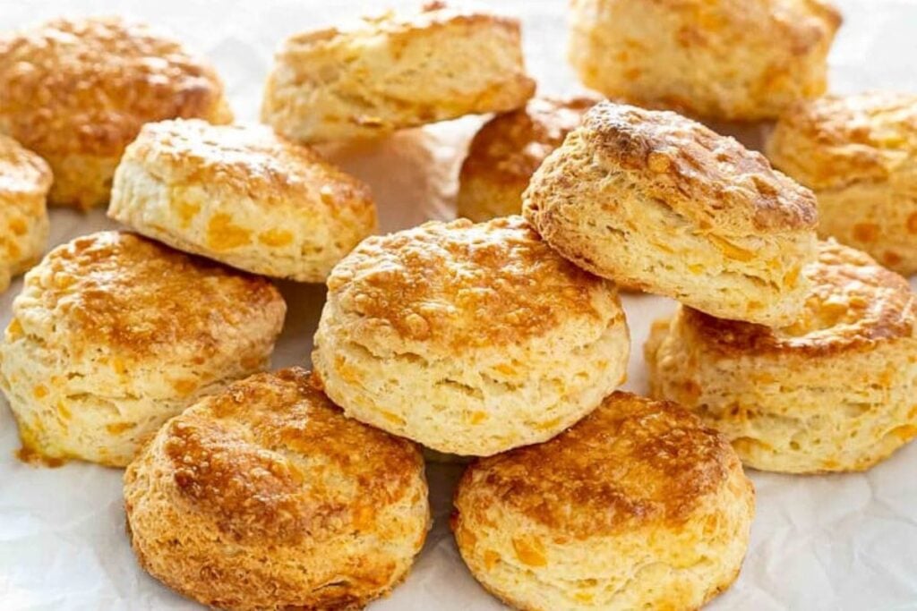 A platter of flaky cheddar cheese biscuits.