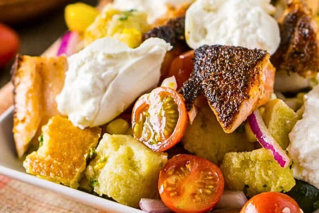 A tray of salmon and panzanella salad.