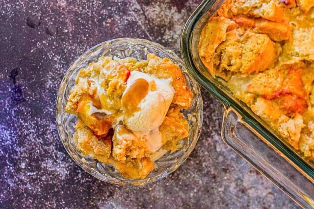 A dish of peach bread pudding with caramel sauce.